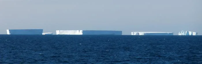 A group of icebergs sitting in water
